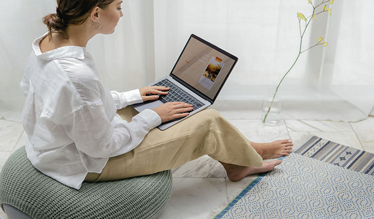 mulher usando o computador para procurar imóveis na internet. Um possível lead a ser captado